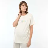Camiseta de lactancia de manga corta color blanco marfil, con estampado frontal multicolor que dice "MAMMA POWER" en letras de distintos tonos.