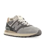 Championes urbanos New Balance modelo 574, con diseño en tonos grises y detalles en marrón. Confeccionados en una combinación de gamuza y malla, cuentan con el logo lateral característico y entresuela con tecnología ENCAP para mayor amortiguación.