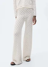 Pantalón de tiro medio con diseño recto y largo, confeccionado en tejido de punto calado con textura geométrica. Cuenta con cintura elástica para mayor comodidad.