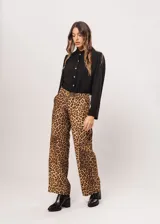 Camisa negra de cuello redondo con frunces y mangas largas con puños abiertos.