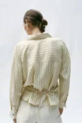 Camisa de rayas con cuello solapa y manga larga, con diseño cruzado en el frente y cierre de botones.