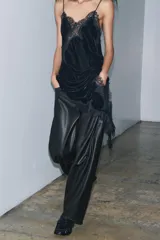 Pantalón de tiro medio confeccionado en tejido efecto piel. Presenta un diseño de pierna ancha tipo balloon, cintura con trabillas, cierre frontal con cremallera y botón, y cinco bolsillos.