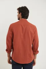 Camisa de cuello mao y manga larga, confeccionada en una mezcla de lino y algodón. Presenta un diseño de corte recto con botones en tono natural y un bolsillo pequeño en el pecho.