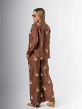 Conjunto de camisa y pantalón marrón chocolate con bordados en hilo crudo. El pantalón lleva elástico en la cintura.
