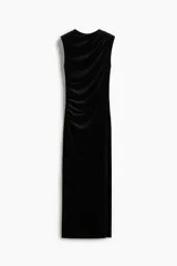 Vestido largo sin mangas confeccionado en velour suave. Presenta un diseño entallado con cuello alto y un efecto drapeado creado mediante pliegues estratégicos en el hombro y en el lateral de la cintura.