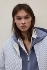 Chaqueta reversible de calce regular con diseño a rayas, cuello redondo, cierre frontal con broches y bolsillos laterales.