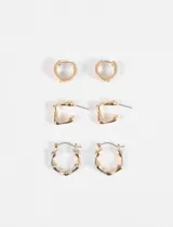 Set de tres pares de aros dorados con diferentes diseños: aros tipo argolla con textura martillada, aros tipo argolla con forma irregular y aros tipo botón con forma irregular.