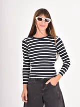 Remera de manga larga con cuello redondo, confeccionada en tejido de punto con diseño de rayas horizontales en color negro y blanco.