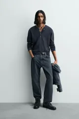 Camiseta de manga larga para hombre con corte relajado, confeccionada en tejido con estructura waffle. Presenta un cuello redondo tipo panadero con cierre frontal de botones a presión.