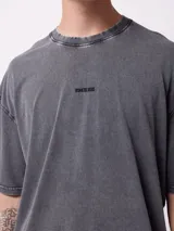 Remera oversize de color gris oscuro con efecto acid wash, mangas cortas y cuello redondo. Cuenta con un pequeño estampado frontal con la inscripción "DIXIE".