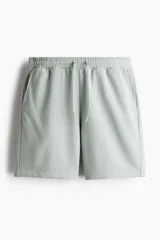 Short deportivo color verde claro, de corte regular, con cintura elástica ajustable con cordón, bolsillos laterales y un bolsillo trasero.