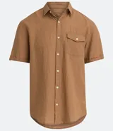 Camisa de hombre de manga corta color marrón, confeccionada en lino y algodón. Presenta cuello clásico, botonadura frontal, bolsillo en el pecho y mangas con botón para enrollar.