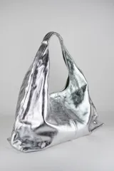 Cartera de cuero vacuno con pelo en diseño animal print similar a piel de ciervo, silueta triangular y asa integrada.