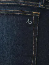 Jean de tiro medio, color azul oscuro, corte skinny y bolsillos delanteros y traseros.