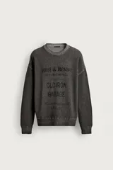 Sweater relaxed fit de algodón color gris con efecto lavado, cuello redondo, manga larga y diseño de textos estampados a contraste en el frente.