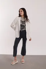 Blazer blanco con rayas verticales finas, de corte clásico con solapas y bolsillos delanteros.