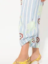 Pantalón de lino liviano con estampado de rayas verticales y flores. Tiene un fit relajado y largo modular ajustable con jaretas laterales.
