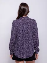 Camisa estampada azul con lunares blancos y rosados, de corte holgado y manga larga con puños abotonados.