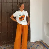 Pantalón de mujer color naranja, de corte palazzo y cintura alta con cordón ajustable.