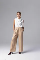 Pantalón de vestir color beige, de corte palazzo y tiro alto, con pinzas delanteras y botón decorativo en la cintura.