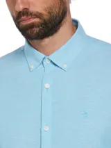 Camisa celeste de manga larga con cuello abotonado, corte clásico y logo bordado en el pecho.