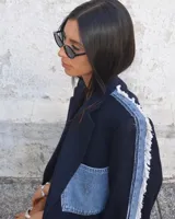 Blazer oversize de diseño, confeccionado en tela azul marino con detalles de denim deshilachado en las mangas y un bolsillo de parche de denim con logo bordado en el pecho.