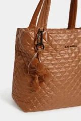 Cartera tote maxi bag color negro, con diseño acolchado y pespuntes en rombos. Cuenta con doble asa de mano, correa ajustable y extraíble, cierre superior y detalle de llavero con pompón y borla colgante.