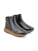 Bota corta de cuero negro con cierre lateral y suela de plataforma color tostado.