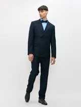 Ambo de doble abotonadura color azul marino, confeccionado en tejido con spandex. Saco de solapas en punta, hombros estructurados y bolsillos con solapa. Pantalón de corte recto con pinza frontal.