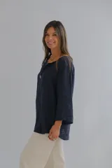Blusa azul marino de lino con cuello en V, manga 3/4 y cierre frontal con un botón.