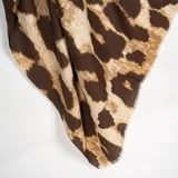 Pashmina de tejido ligero con estampado animal print en tonos marrones y beige, con bordes desflecados.