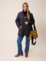 Bolso tipo bandolera de lona color mostaza, con dos bolsillos frontales con solapa y cierre de broche a presión. Cuenta con correas de hombro negras y una correa larga ajustable y extraíble. Presenta herrajes metálicos en tono bronce.