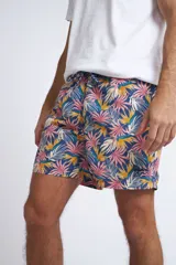 Short de baño con cintura elástica y cordón ajustable, confeccionado en tela ligera de secado rápido. Presenta un estampado botánico integral en tonos amarillos, blancos y azules, con dos bolsillos delanteros y uno posterior.