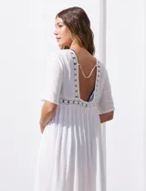 Kaftan largo de playa color blanco, con mangas cortas, escote en V y detalles de puntilla en el frente. Presenta una abertura central con lazo de ajuste en la cintura.