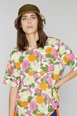 Gorro tipo bucket reversible con estampado floral en tonos rosa, amarillo y verde de un lado, y verde militar liso del otro.