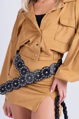 Minifalda negra de gamuza sintética con tajo lateral y cinturón con tachas plateadas.