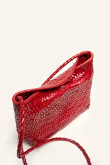 Cartera tipo morral y bandolera de cuero vacuno marrón, completamente trenzada a mano con diseño estructurado y correa larga trenzada.