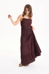 Vestido largo color blanco, confeccionado en lino, con tiras finas regulables, escote recto y falda amplia de corte acampanado con volados escalonados.