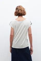 Blusa de mangas cortas con estampado abstracto en tonos blanco, azul y negro.