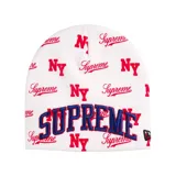 Gorro de lana tipo beanie color blanco con estampado integral de logotipos Supreme y NY en color rojo. Presenta un bordado frontal grande con la palabra SUPREME en letras azules con borde rojo y el logo de New Era en el lateral.