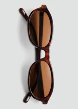 Lentes de sol Femme con montura ovalada de pasta con estampado carey y cristales marrones.