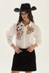 Falda corta de cuero color marrón, con diseño de flecos largos desmontables que cubren toda la prenda. Presenta un estilo western con cierre en la cintura.