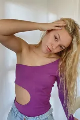 Body asimétrico violeta de algodón con lycra, con un hombro descubierto y manga larga. Presenta un corte en la cintura.