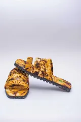 Sandalias planas con capellada de algodón estampada con diseño batik en tonos rosa y negro. Suela de neumáticos reciclados.