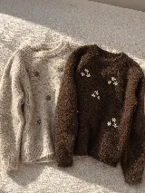 Sweater de punto con textura suave y diseño de flores bordadas dispersas. Presenta cuello redondo, mangas largas y puños acanalados.