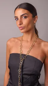 Collar corbatero de acero dorado con eslabones circulares texturizados entrelazados en diseño largo.