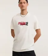 Remera de algodón color blanco, corte comfort, con cuello redondo y manga corta. Presenta un estampado grande en la espalda con un auto de carrera estilo Fórmula 1, un diagrama de circuito y varios textos gráficos relacionados con carreras.