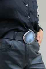 Cinto de cuero azul con hebilla circular de piedra ágata con borde dorado.