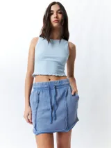 Minifalda color beige con elástico en la cintura, cordones ajustables y costuras marcadas en los laterales.