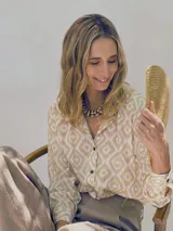Camisa de fibrana de estilo clásico, con estampa ikat en tonos beige y blanco, cuello camisero, mangas largas y botones de coco en la parte frontal.
